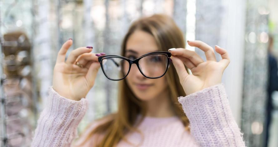 Young student girl is preraring for college study and try new glasses for her perfect look in store